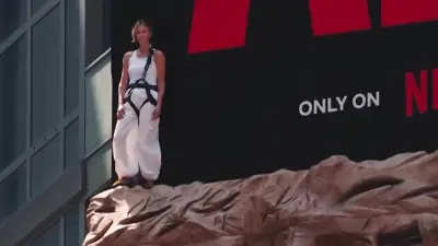 Charlize Theron erklimmt Felswand am Times Square für Filmwerbung