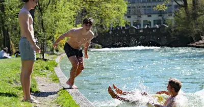Münchner Frühling lockt mit eiskaltem Badespaß im Eisbach trotz frischer Temperaturen