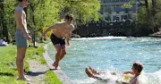 Münchner Frühling lockt mit eiskaltem Badespaß im Eisbach trotz frischer Temperaturen