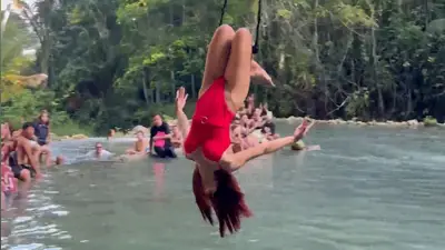 Touristin schwebt kopfüber über Lagune an Philippinen-Wasserfällen